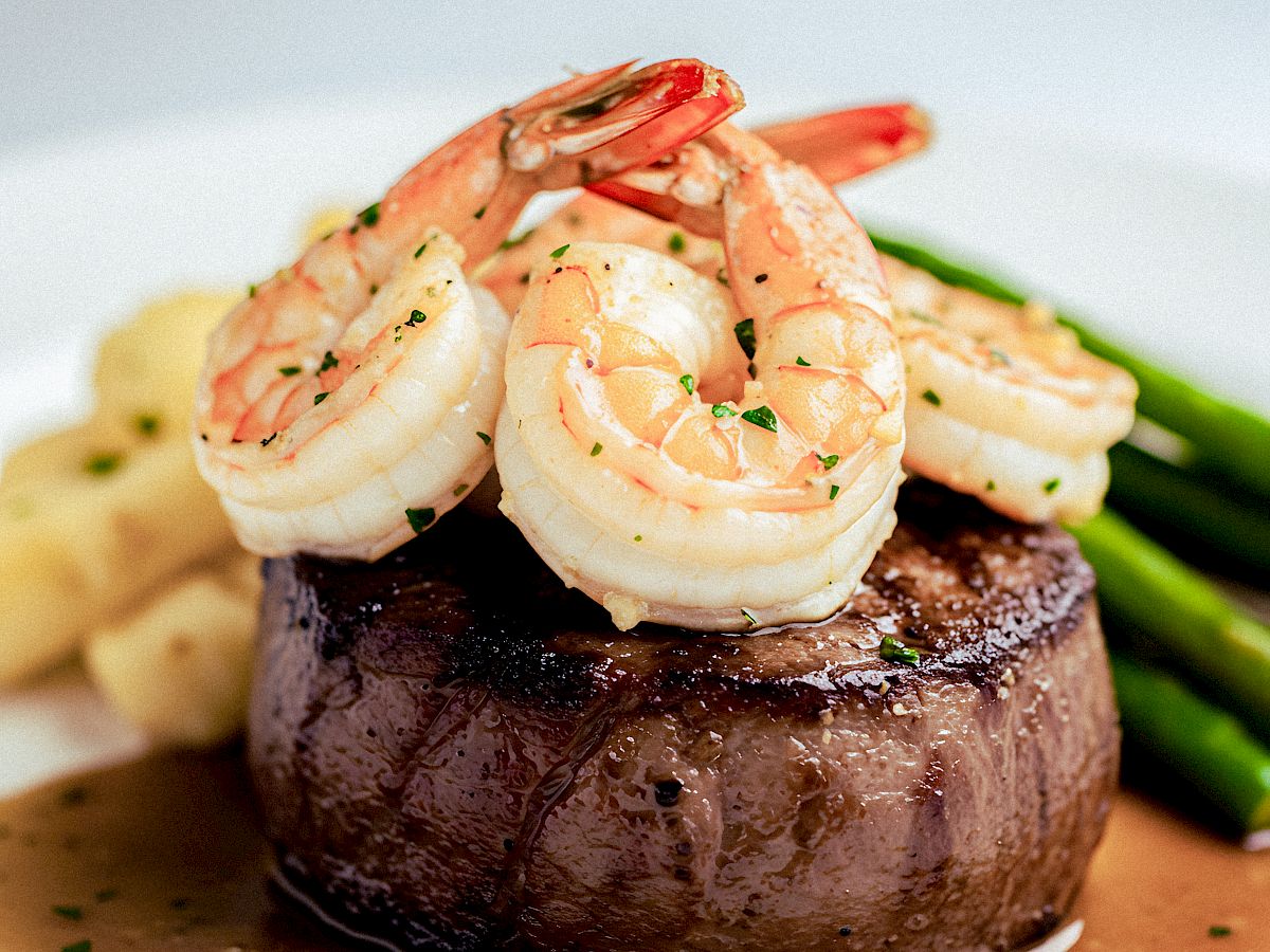 Succulent beef filet topped with crawfish tails, served on a rich sauce with asparagus and mashed potatoes, an elegant surf-and-tine plate.